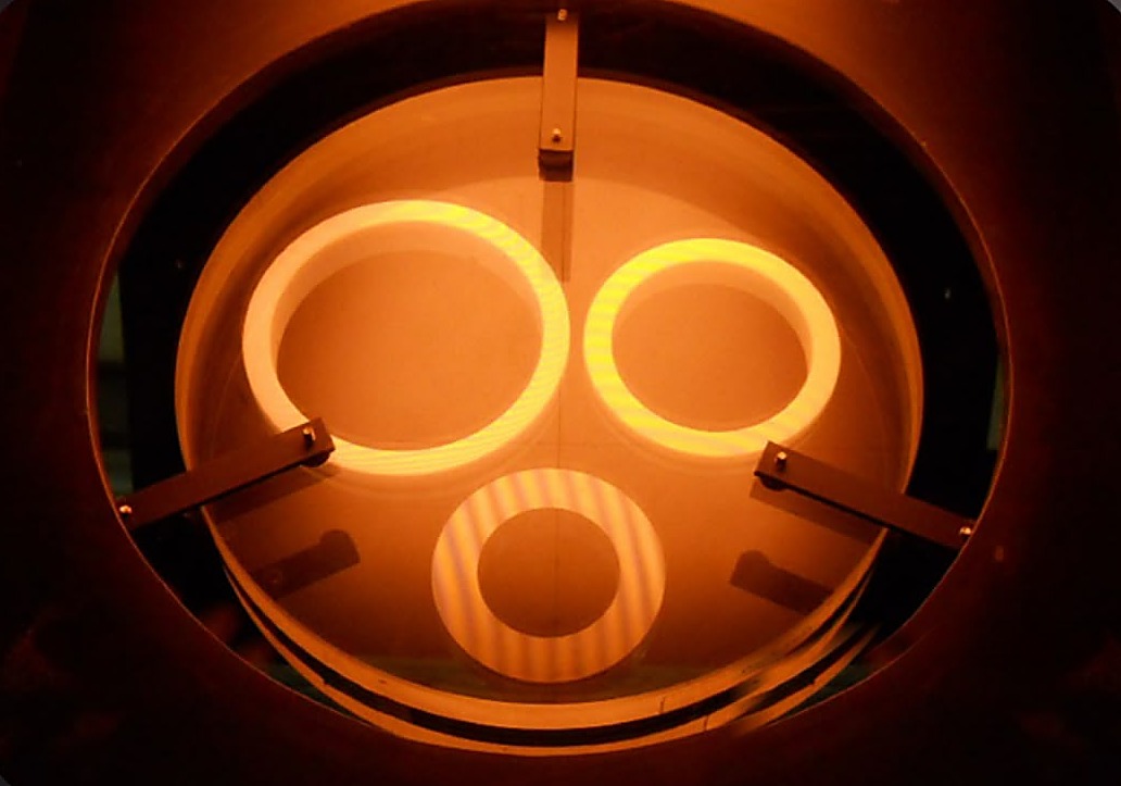 Lapped seal faces under a monochromatic light box, showing interference fringes through an optical flat